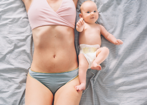 a woman lying on a bed with a baby